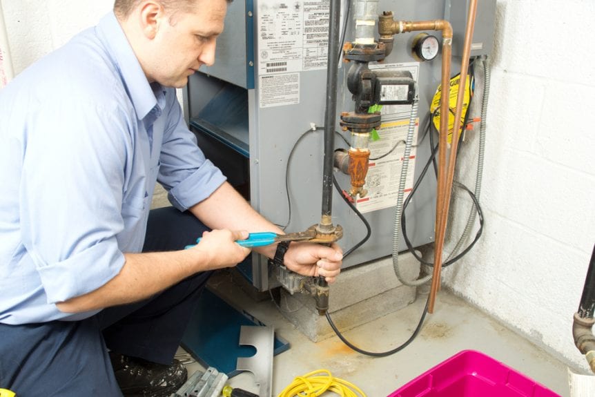 A technician repairing a furnace | air conditioning maintenance