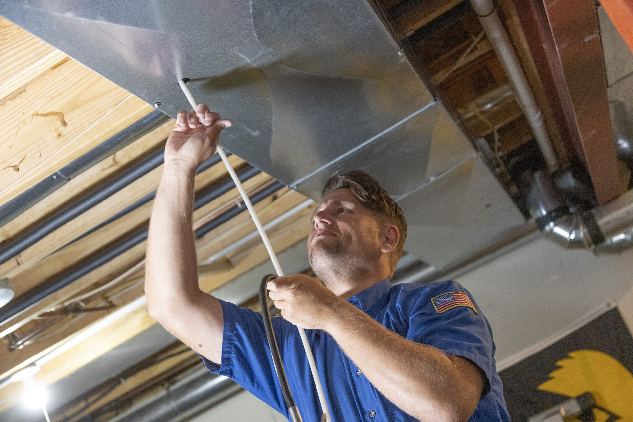 employee inspecting duct